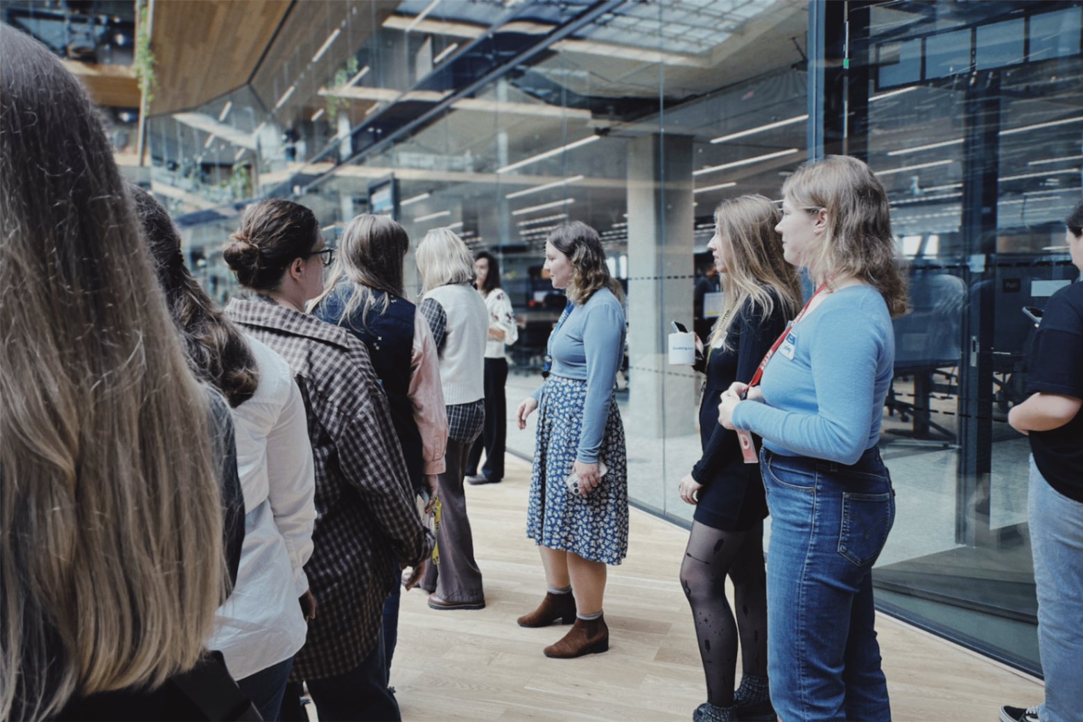 Delegation participants during an office tour, gathered in a bright corridor space