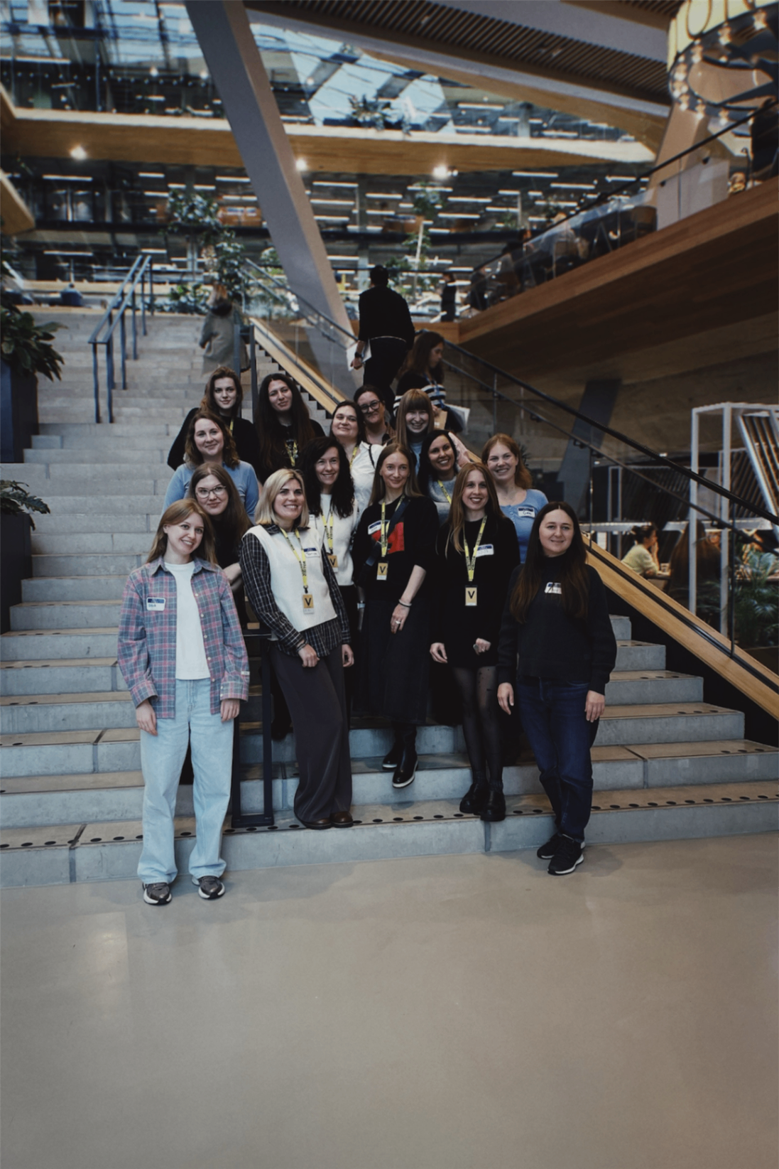 The delegation cohort gathered together on a staircase inside a modern office building