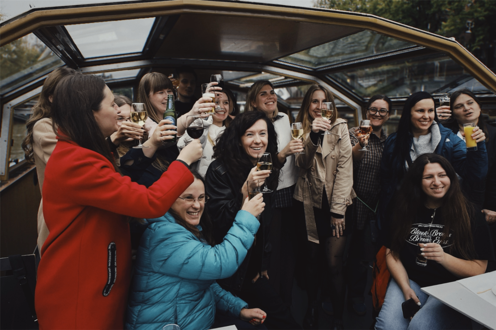 Delegation participants raising glasses together on a boat, sharing a warm celebratory moment