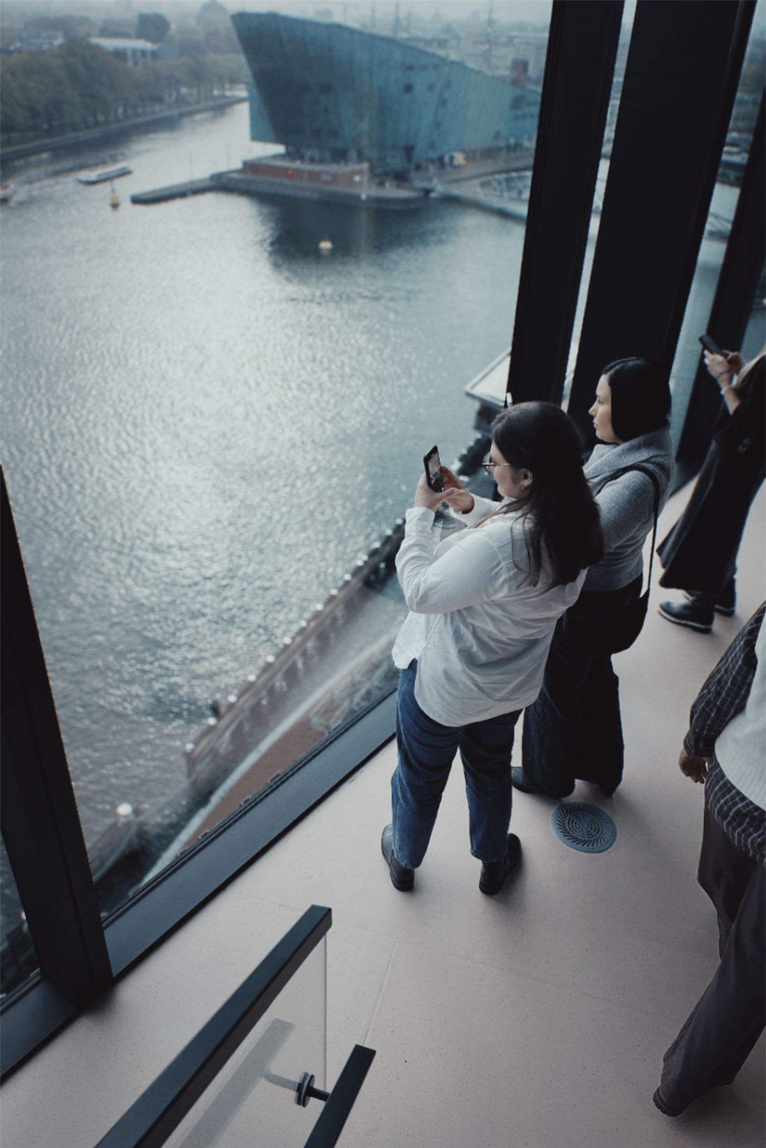 Participants looking out over the water and city from a large window during the delegation